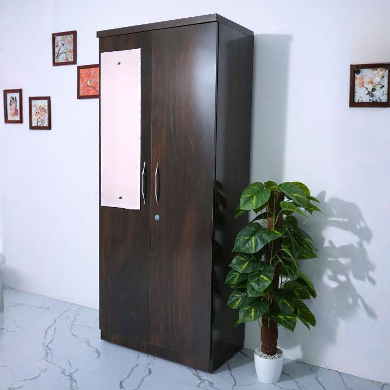 6.25 feet tall wooden two door wardrobe with 3 feet mirror on a white wall with decorative frames.