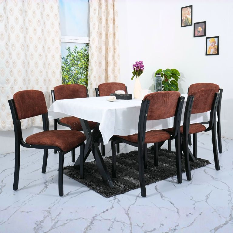 Dining table set with brown chairs and a white tablecloth in a room with curtains and decor.