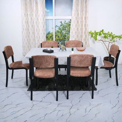 Dining table set with chairs in a room with large windows and white curtains.