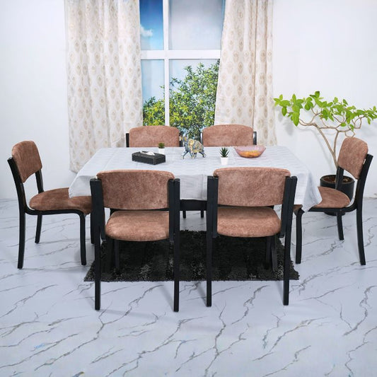 Dining table set with chairs in a room with large windows and white curtains.