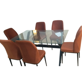 A modern 6-piece dining set featuring a rectangular glass-top table with a black metal frame and six upholstered dining chairs in a rust-orange color, set against a plain white background.